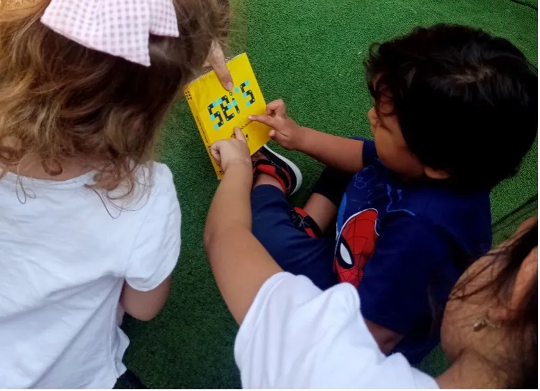 Children gathered around a colorful educational toy, learning to recognize numbers in a fun, interactive way.