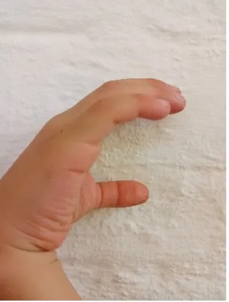 A child's hand forms a sign in Colombian Sign Language, representing an inclusive approach to communication.